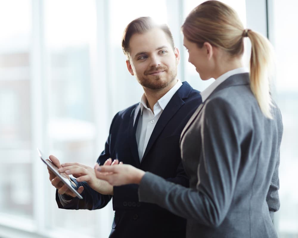 Dos personas de perfil comercial revisando datos de un lead en una tablet